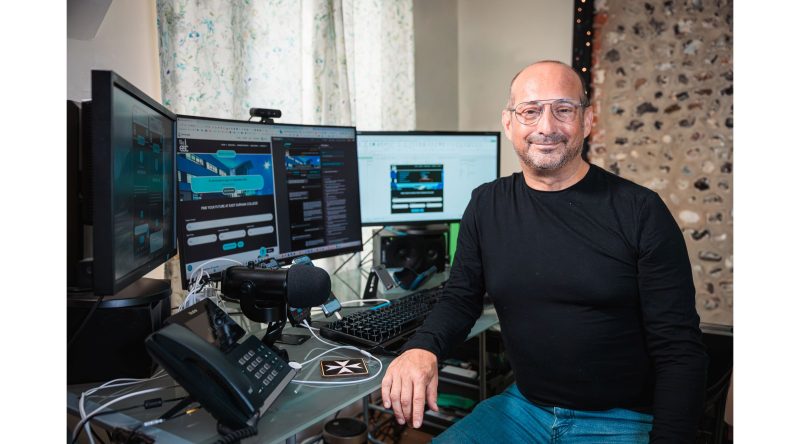 Clive is at his desk, smiling