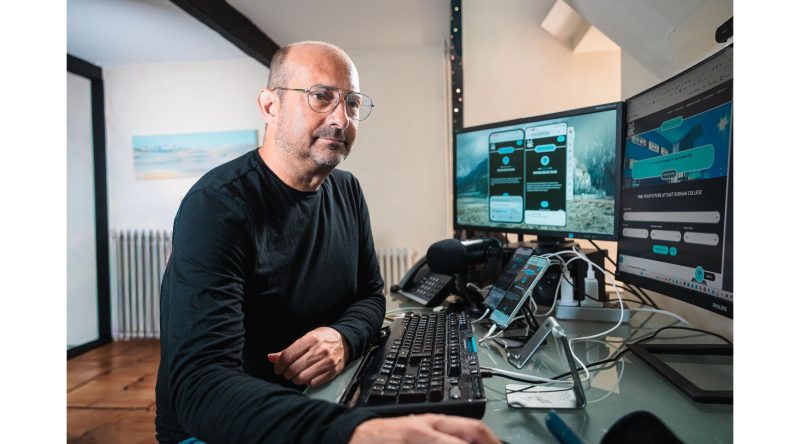 Clive is at his desk, which consists of three computer monitors, two mobile phones, and a lot of accessibility testing programmes on the screen